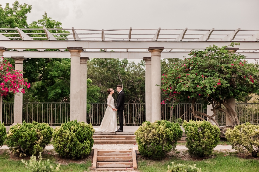 bride and groom under arch at selby gardens historic spanish point by amanda dawn photography