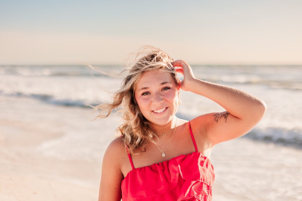 Senior girl in bright top posing at St. Petersburg Beach.