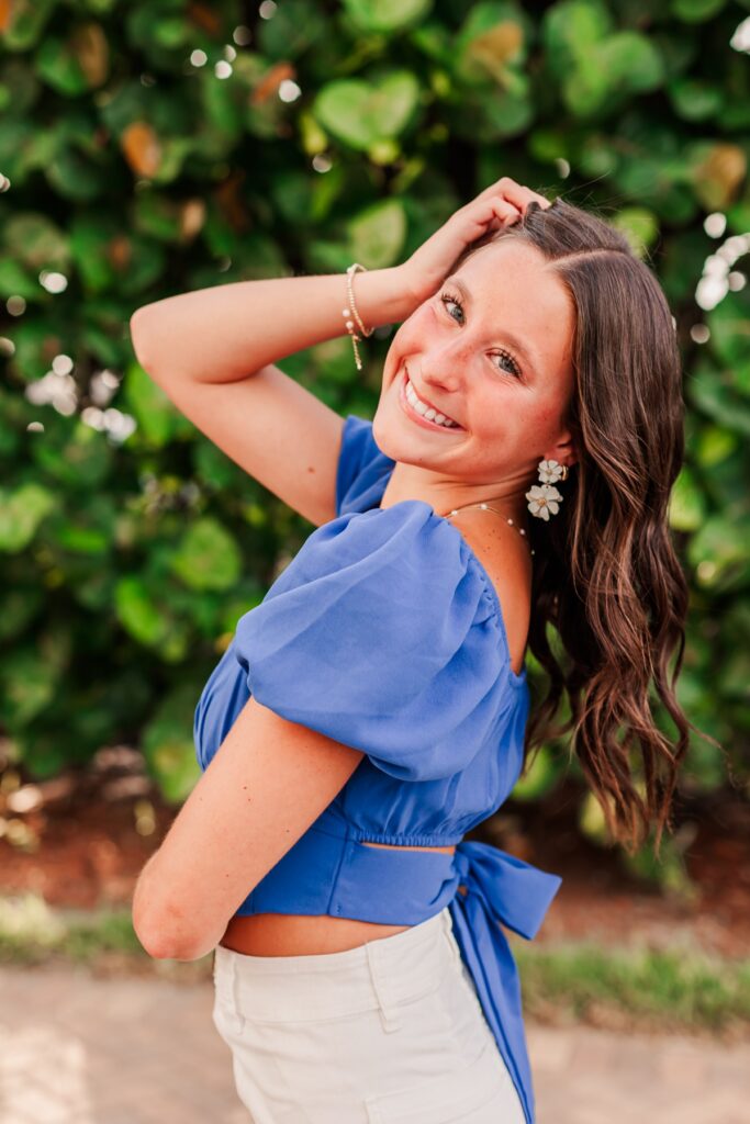 Senior posing in bright blue top for Senior Portraits at Madeira Beach captured by Amanda Dawn Photography