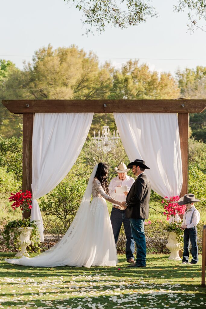 bride and groom holding hands during ceremony at southern barn venue.