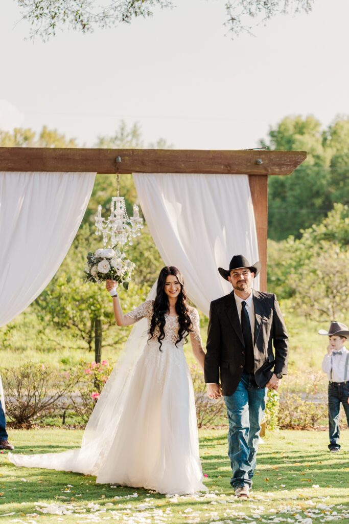 Bride and groom walking back down the aisle after wedding ceremony.