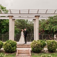 bride and groom under arch at selby gardens historic spanish point by amanda dawn photography